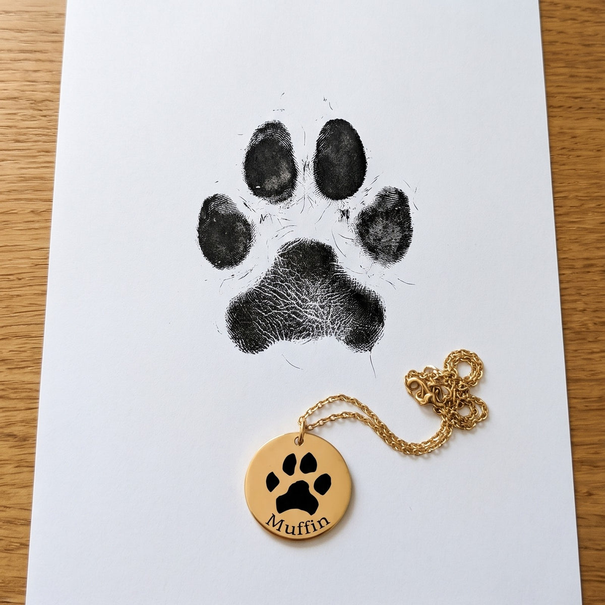 Huella de perro estampada con tinta en papel junto al collar con su huella